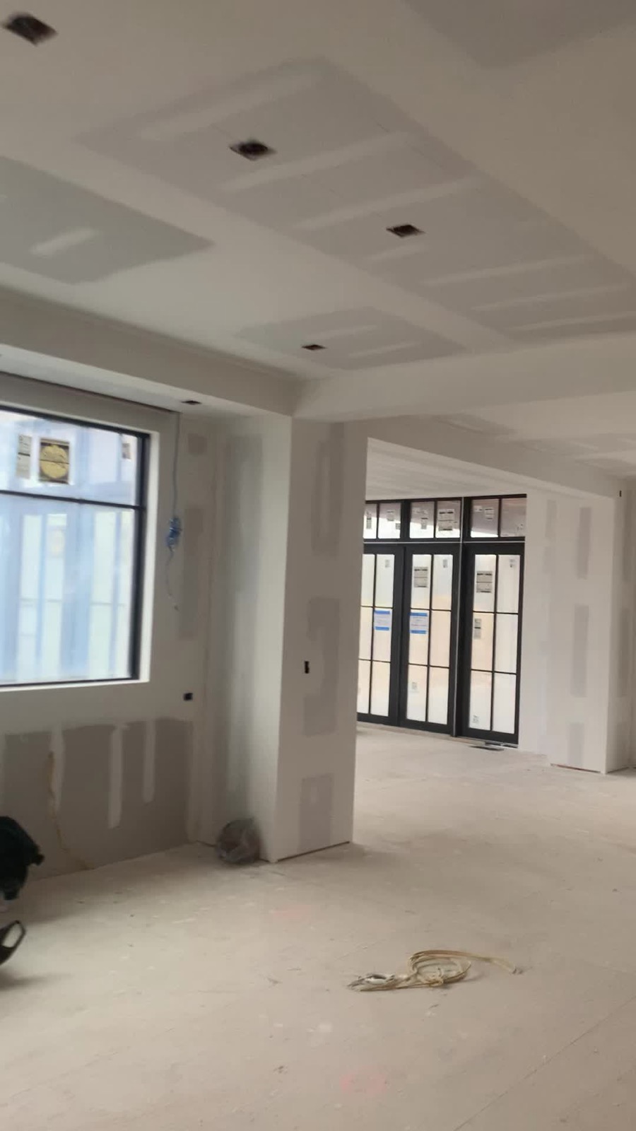 New construction great room, coffered ceiling and black-framed windows, taped and sanded